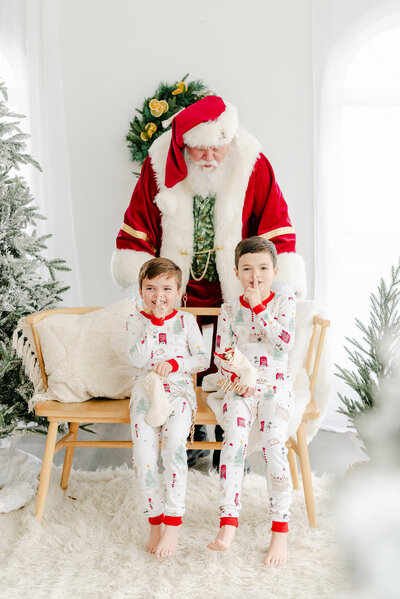 Boys in Christmas Pajamas with Santa sneaking in behind them