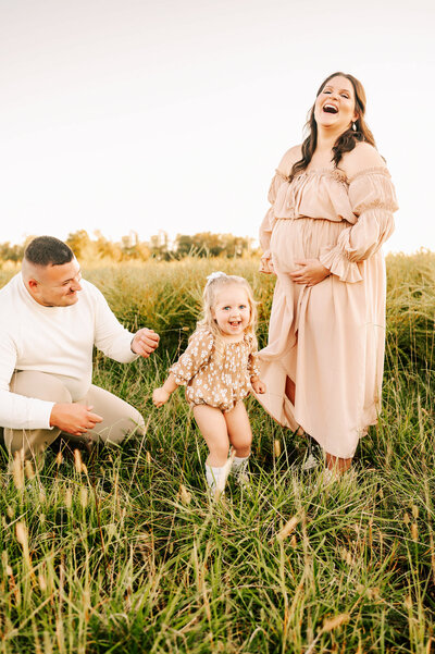 pregnant mom laughing with family during Branson Mo maternity photography session