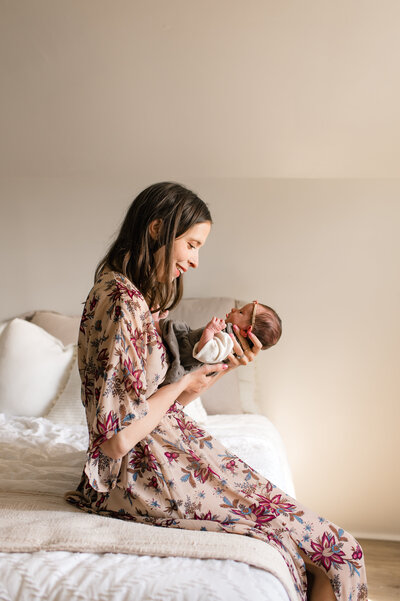 Father gazing lovingly at his newborn baby during a family session in Cypress, TX.