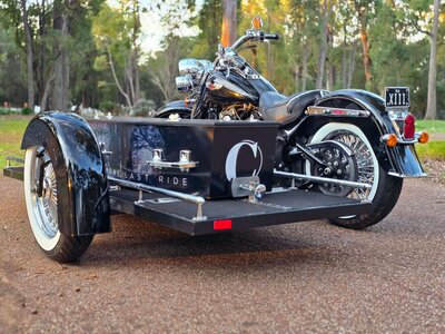 Harley Davidson hearse carrying a casket at a Perth cemetery, providing a personalised farewell.