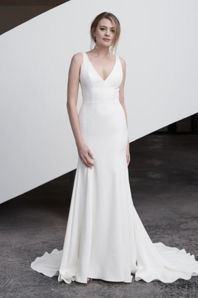We crafted our jewel satin Kitt with a chapel train, a pair of (very necessary) pockets, and a modern square neckline for brides who are wanting something classic with a contemporary twist.