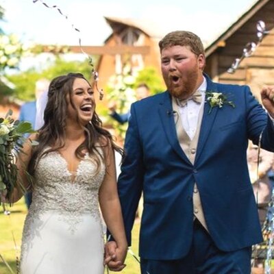 Clients of E Stokes Creations, bride and groom, celebrating and smiling as they walk down the aisle after their wedding ceremony