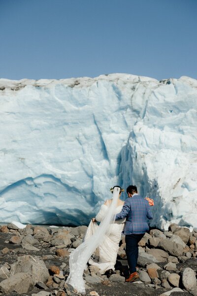 Adventurous couple trekking through a snow-covered Alaskan pass.