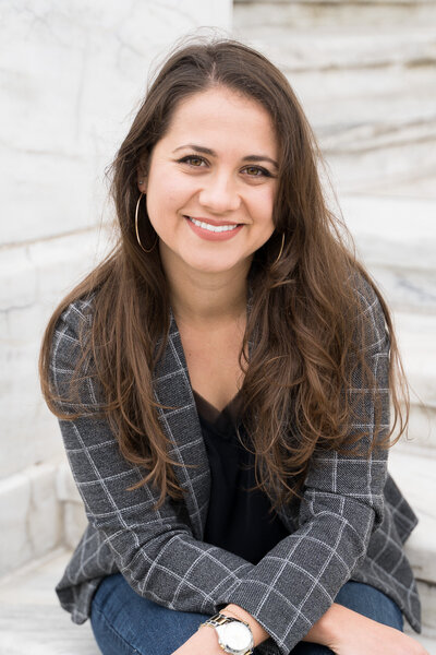 Taylor Ingles standing with her arms folded wearing a blazer leaning against the DIA building in Detroit