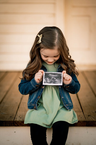 Little girl holding sonogram
