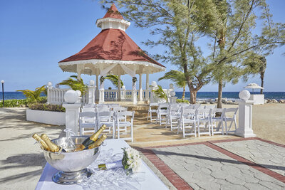 Wedding ceremony site with chairs and has welcome wine drinks