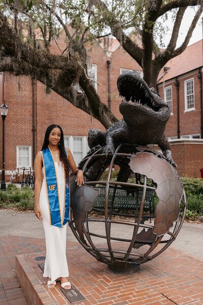 uf grad posing on university of florida campus with alligator statue