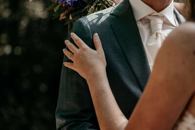 hand van de bruid op de schouder van de bruidegom