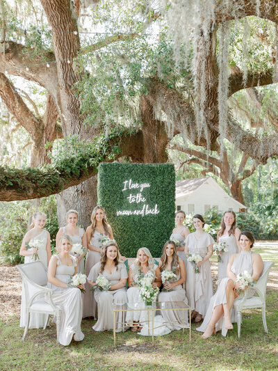 bride with bridesmaids posing for a photo among the moss