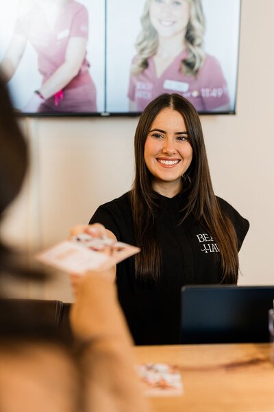 Esthetician checks out a customer after her waxing service