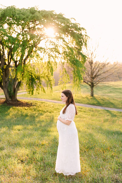 Pregnant mama holds growing pregnant belly at the beautiful biltmore estate for her Asheville Maternity Session with Asheville Maternity Photographer Rachel Marie Photography