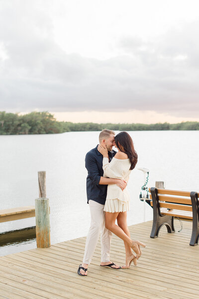 Couples photographer in Orlando captures couple standing on a dock holding each other at sunset