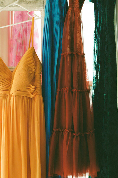 close up bridesmaid's dresses hanging in window