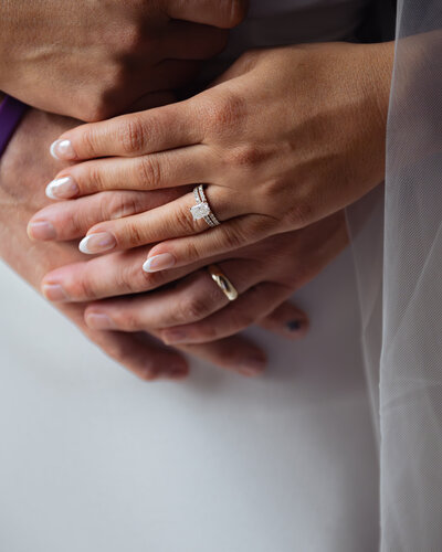 A catholic bride and groom pose their hands with their new wedding bands after their catholic wedding at st. ann's in nashville, tennessee