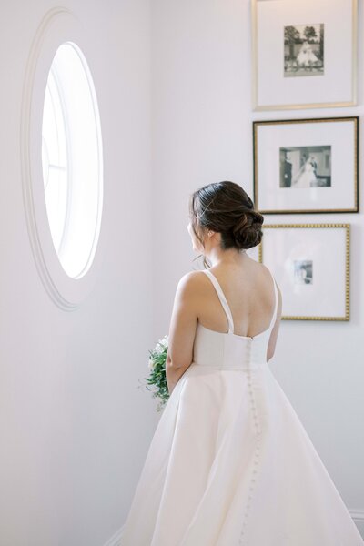 Bride looking out the chapel window at  the Nest at Ruth Farms in ponder, Texas