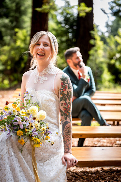 A bride and groom share a joyful moment in a lush Humboldt redwood forest, captured beautifully by a Northern California wedding photographer.