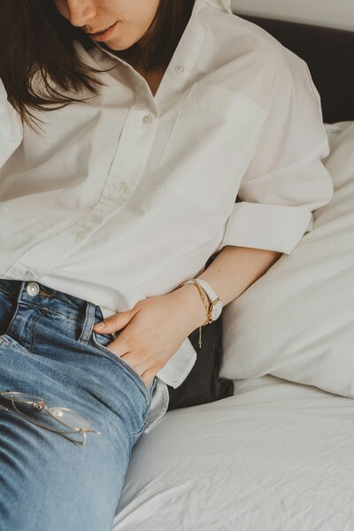 woman in white shirt and jeans with hand in pocket