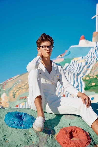 Teen guy leaning against artwork at Salvation Mountain in California for edgy senior portrait session