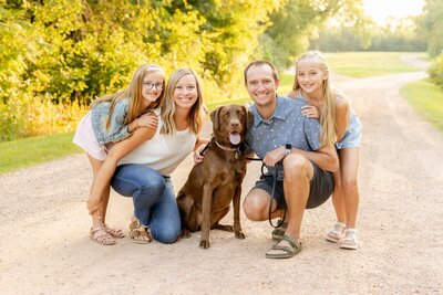Family with dog smiling, taken by wedding photographer minneapolis mn
