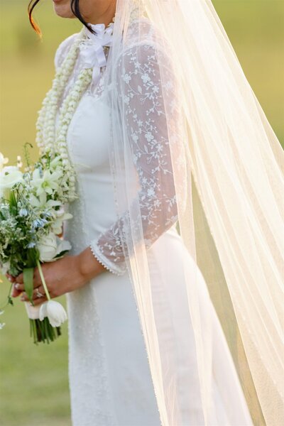 A person in a wedding dress holding a bouquet of flowers 