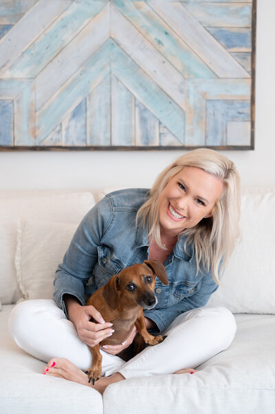 woman sitting on couch with small dog