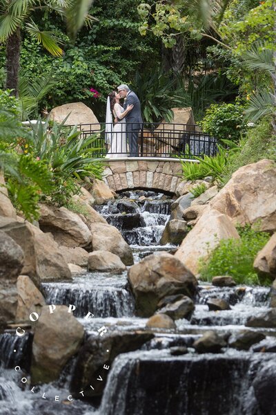 Bride and Groom kissing on bridge at the Grand Traditions wedding venue