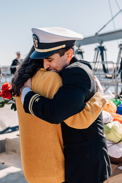 Naval officer embraces spouse in emotional reunion at USS North Dakota homecoming in Groton, CT.