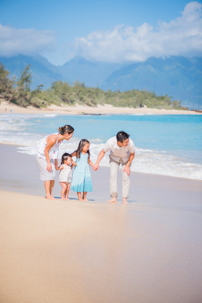 family plays at Baldwin Beach on Maui for their sunrise photo session