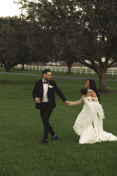 Bride and Groom running in an open field on their wedding day planned by Everlasting Events Austin Wedding Designer