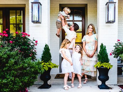 family of 3 on front porch playing