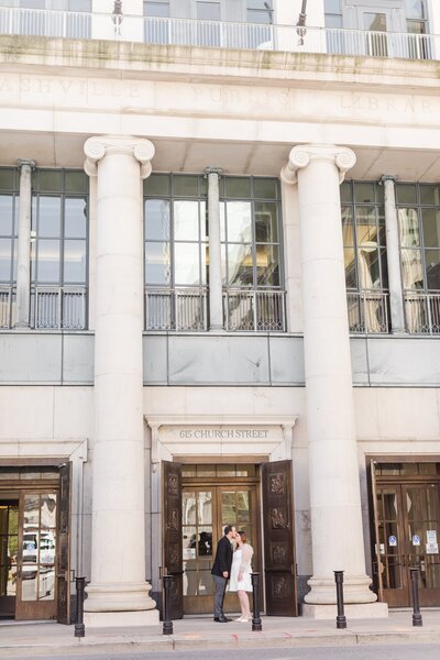 groom kissing bride on forehead during their Nashville engagement session at the Nashville Public Library