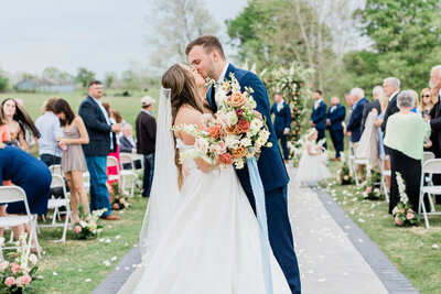 bride and groom kiss after down the aisle after ceremony in Northwest Arkansas at Willow Brooke Farm