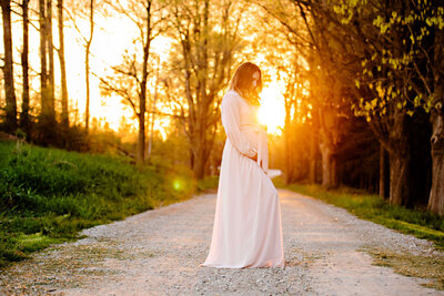Golden hour maternity session with pregnant mom wearing a pink dress for her Burlington Maternity photography session.