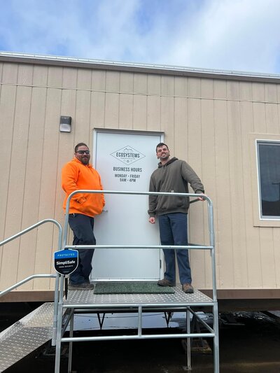 Employees smile near a door at the Ecosystems transfer and recycling office