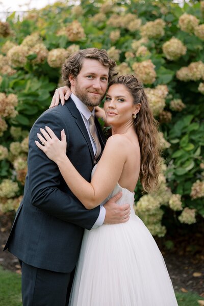 Bride and groom hugging and posing at the camera