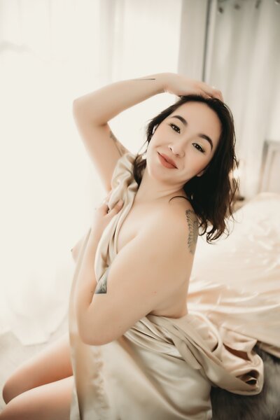 Women has right hand up in her hair as she smiles towards the camera