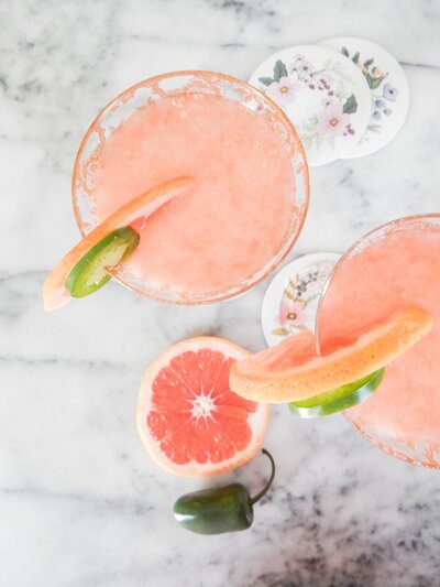 two glasses filled with pink margaritas garnished with grapefruit and lime slices from above for reels editing for socialfizz