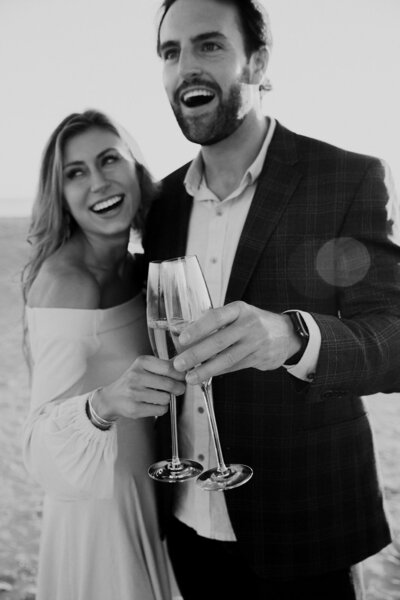 Couple touching glasses with Champagne looking surprised
