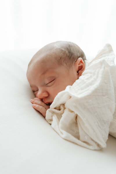 Baby slaapt heerlijk op de buik tijdens haar newbornshoot op een beanbag.