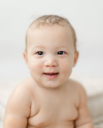 6 month old baby boy smiles for portrait