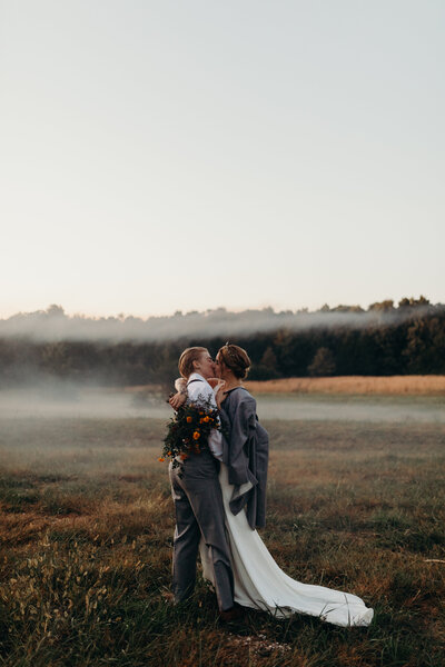 couple posed at outdoor wedding ceremony with fog