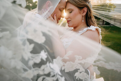 Bride and groom walking hand-in-hand under a stone archway