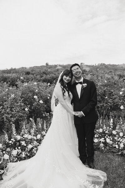 bride and groom smiling while holding hands