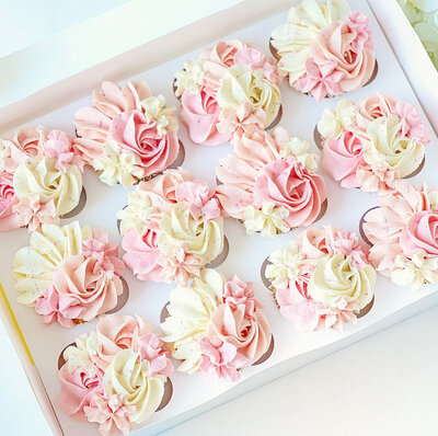 A box of pink & white pretty birthday celebration cupcakes