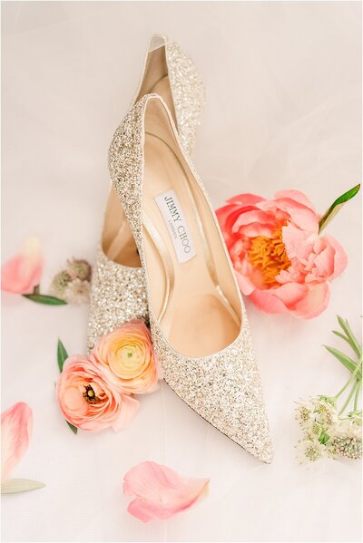 Jimmy Choo sparkling light gold wedding heels surrounded by pink peony flowers