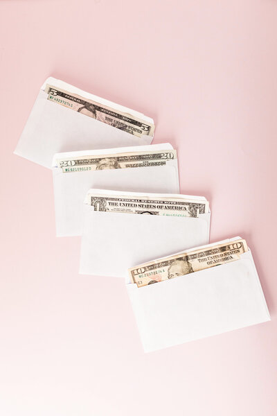 Row of four envelopes stuffed with money