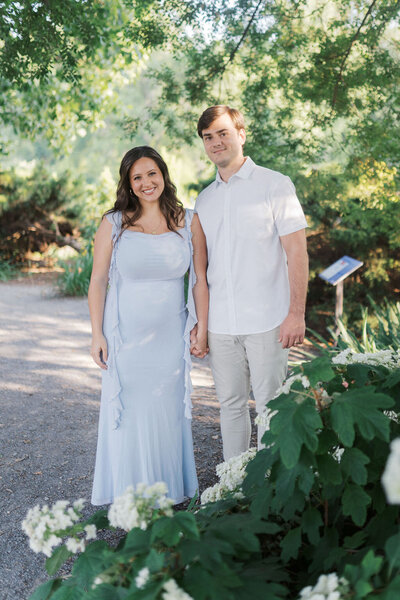 pregnant woman holds husband's hand while standing in the university of tennessee's botanical gardens in knoxville