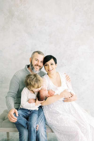 A picture of a family of four a mom a dad and two boys by Lindsay Reed Photography for Dolly DeLong Photography