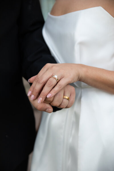 An Austin-based wedding photographer captures a precious moment of a bride and groom exchanging their wedding rings.