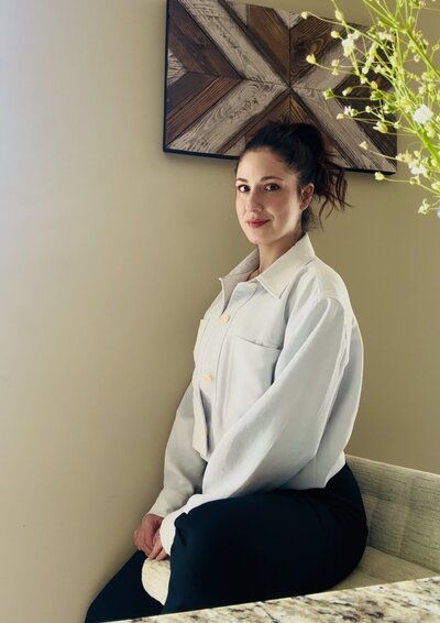 A female copywriter sits calmly looking at the camera wearing a blue jacket 